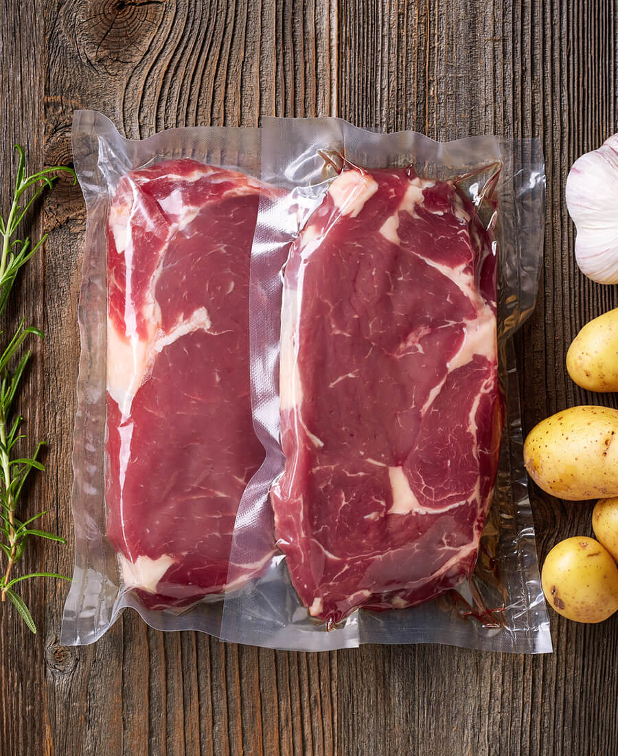 Fresh beef steak for sous vide cooking on wooden table